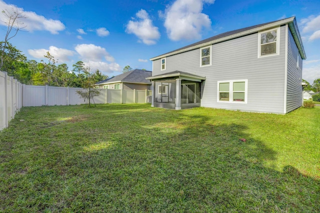 rear view of house with a sunroom and a lawn