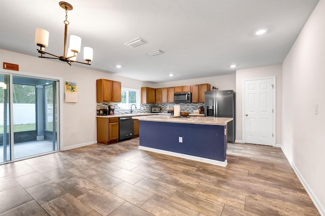 kitchen featuring an inviting chandelier, stainless steel refrigerator with ice dispenser, dishwasher, pendant lighting, and a center island