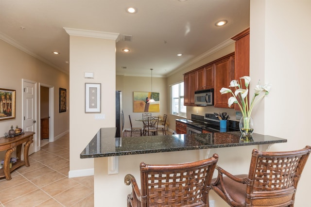 kitchen featuring appliances with stainless steel finishes, light tile patterned floors, dark stone counters, and kitchen peninsula