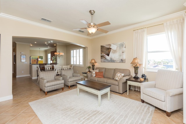 living room with crown molding, light tile patterned flooring, and ceiling fan with notable chandelier