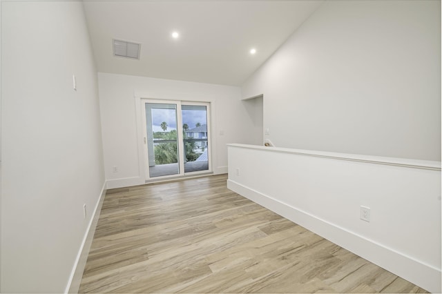 unfurnished room featuring light hardwood / wood-style flooring and vaulted ceiling