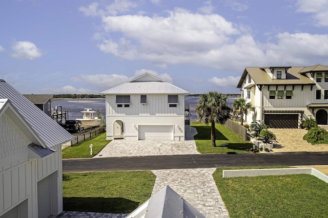 exterior space featuring a water view, a front yard, and a garage