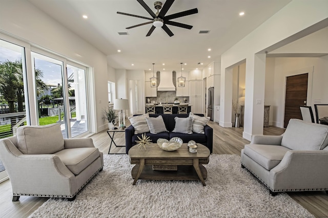 living room featuring ceiling fan and light hardwood / wood-style floors