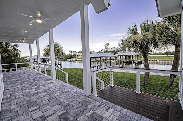 view of patio / terrace with ceiling fan, a water view, and a boat dock