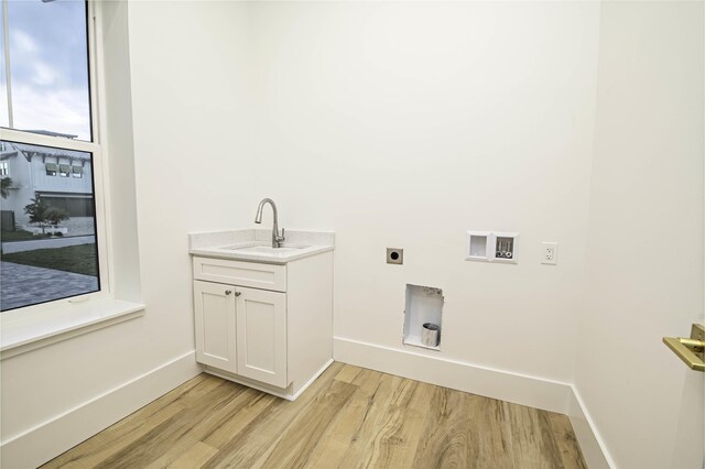 clothes washing area with hookup for an electric dryer, sink, hookup for a washing machine, and light hardwood / wood-style flooring