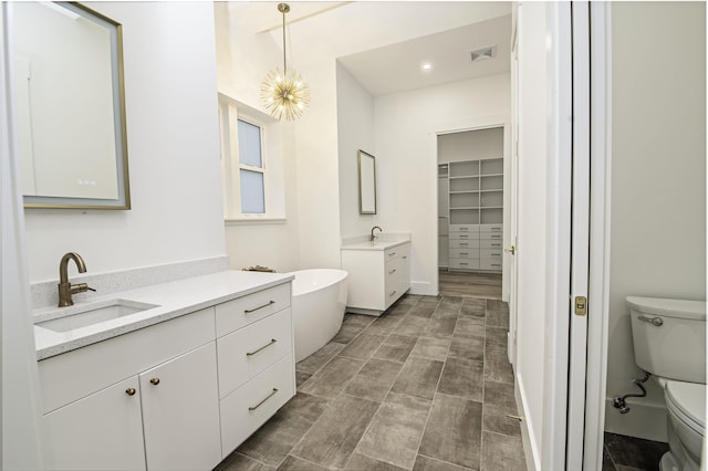 bathroom with hardwood / wood-style flooring, vanity, a notable chandelier, and toilet