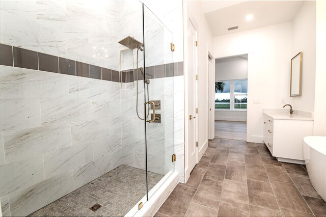 bathroom featuring tile patterned floors, a shower with door, and vanity