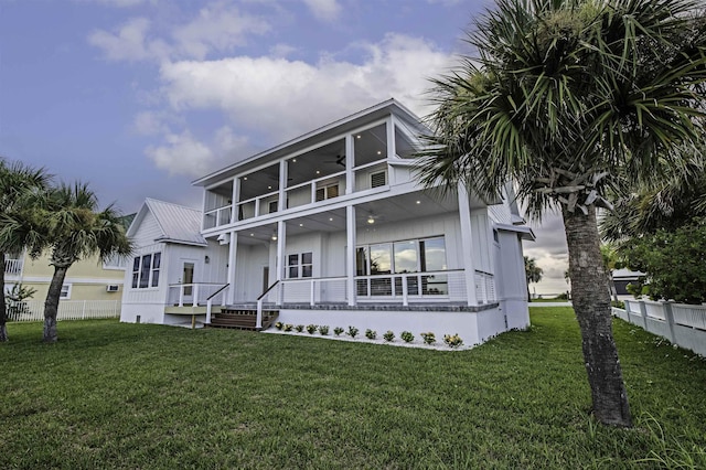 back of property featuring a lawn, ceiling fan, a porch, and a balcony