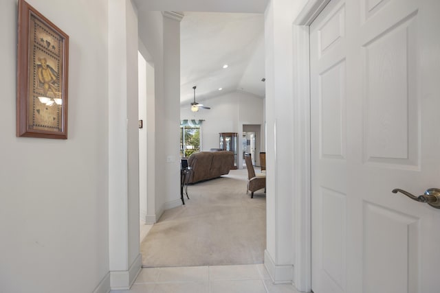 hallway featuring light colored carpet and lofted ceiling