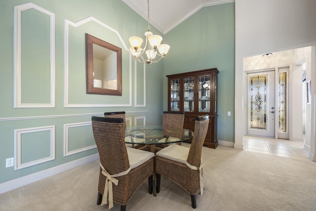 carpeted dining space featuring an inviting chandelier, high vaulted ceiling, and ornamental molding