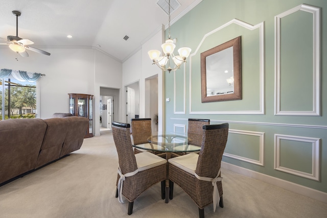 dining area with ceiling fan with notable chandelier, light colored carpet, vaulted ceiling, and crown molding