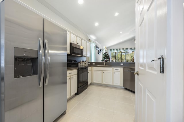 kitchen with appliances with stainless steel finishes, white cabinetry, lofted ceiling, and sink