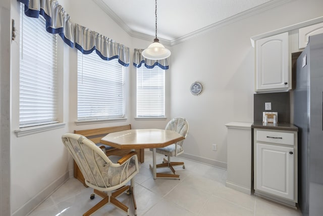 tiled dining space featuring crown molding