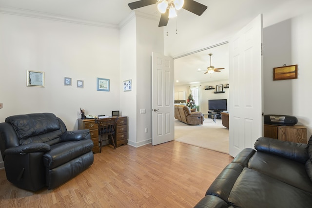 living room featuring crown molding, light hardwood / wood-style flooring, and ceiling fan