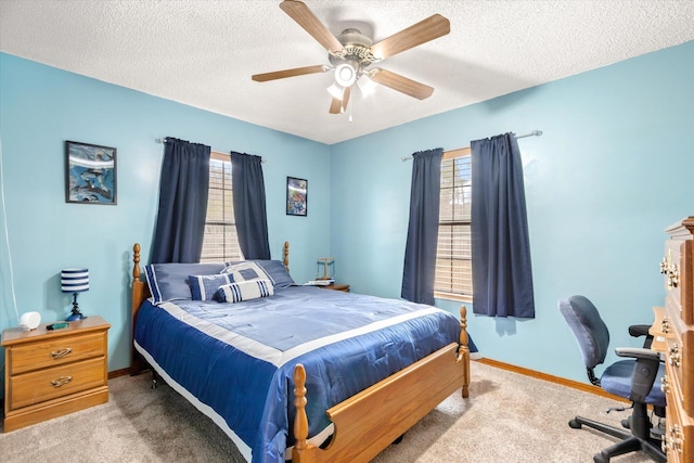 carpeted bedroom featuring ceiling fan and a textured ceiling