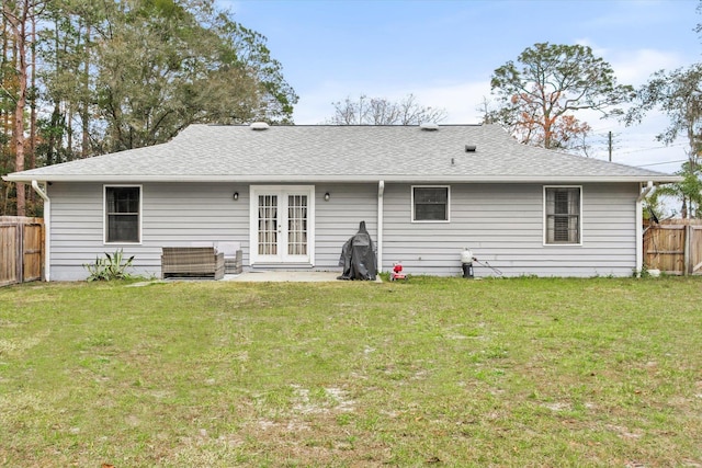 back of property featuring a yard and french doors