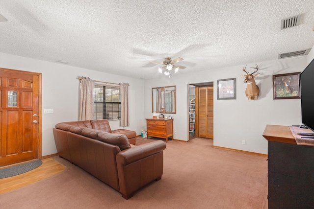 carpeted living room with a textured ceiling and ceiling fan