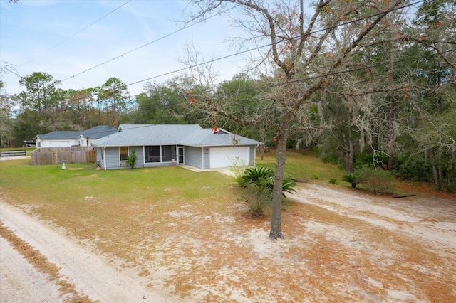 ranch-style home featuring a garage and a front lawn