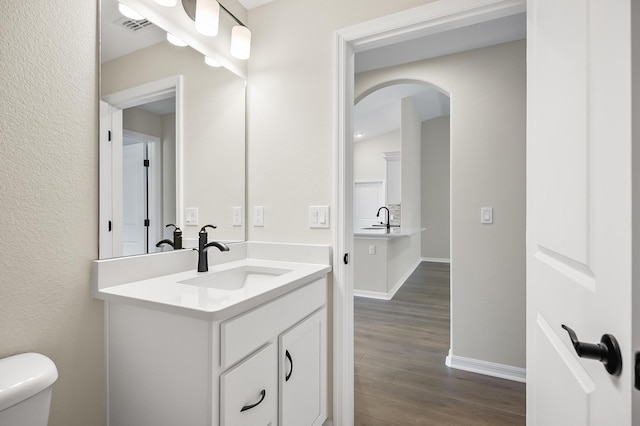 bathroom featuring vanity, hardwood / wood-style flooring, and toilet