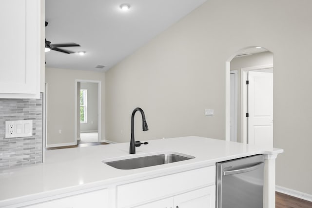 kitchen with stainless steel dishwasher, sink, decorative backsplash, and white cabinets