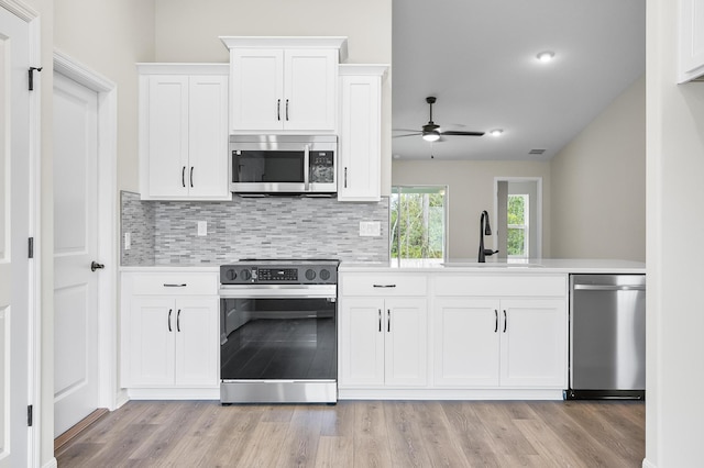 kitchen featuring white cabinetry, sink, stainless steel appliances, and light hardwood / wood-style floors