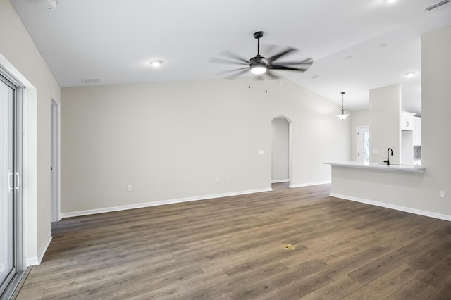 unfurnished living room with lofted ceiling, dark wood-type flooring, sink, and ceiling fan