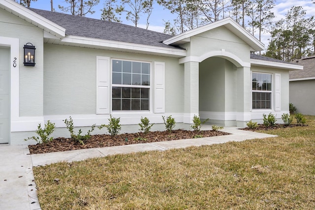 property entrance with a lawn