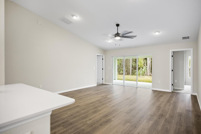 unfurnished living room featuring dark wood-type flooring, ceiling fan, and lofted ceiling