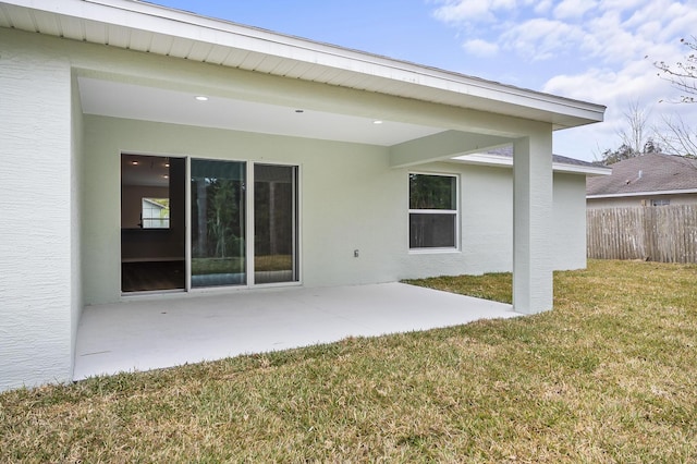 rear view of property featuring a lawn and a patio area