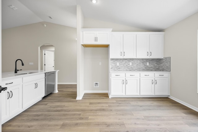 kitchen featuring white cabinetry, lofted ceiling, sink, and stainless steel dishwasher