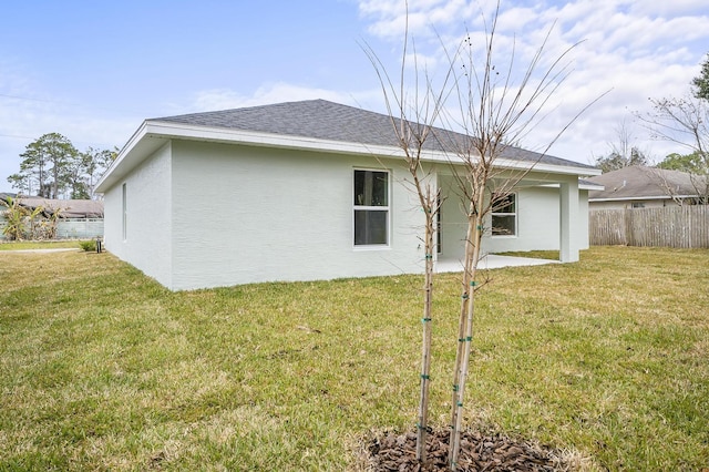 rear view of property featuring a patio and a lawn