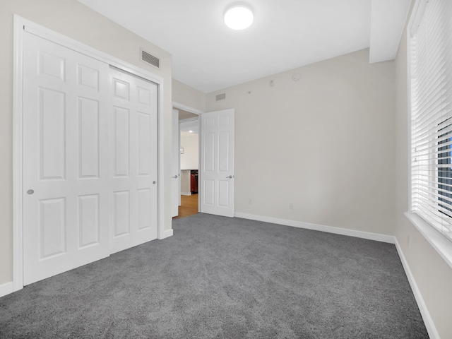 150 Pantano Cay Blvd Unit 2303, Saint Augustine, FL 32080 - unfurnished bedroom featuring dark carpet, a closet, and baseboards