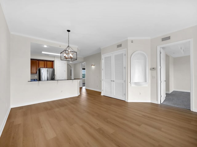 150 Pantano Cay Blvd Unit 2303, Saint Augustine, FL 32080 - unfurnished living room with wood finished floors, baseboards, a chandelier, and crown molding