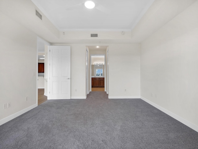 150 Pantano Cay Blvd Unit 2303, Saint Augustine, FL 32080 - unfurnished bedroom featuring dark carpet, baseboards, crown molding, ensuite bathroom, and a tray ceiling