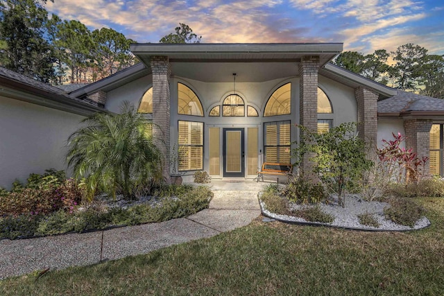 5 Ellington Dr, Palm Coast, FL 32164 - exterior entry at dusk with stucco siding and brick siding