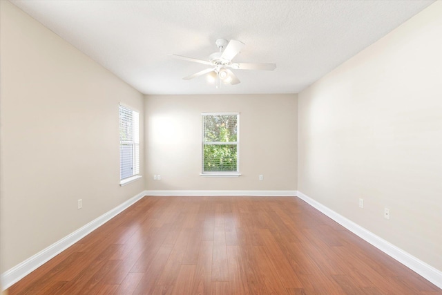 unfurnished room featuring hardwood / wood-style flooring, ceiling fan, and a textured ceiling