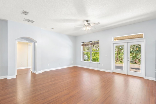 spare room with french doors, ceiling fan, wood-type flooring, and a textured ceiling