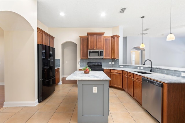 kitchen with a kitchen island, pendant lighting, sink, light tile patterned floors, and black appliances