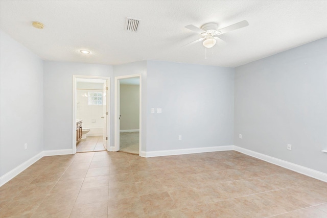 spare room featuring ceiling fan, a textured ceiling, and light tile patterned floors