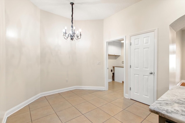 tiled dining room with a chandelier