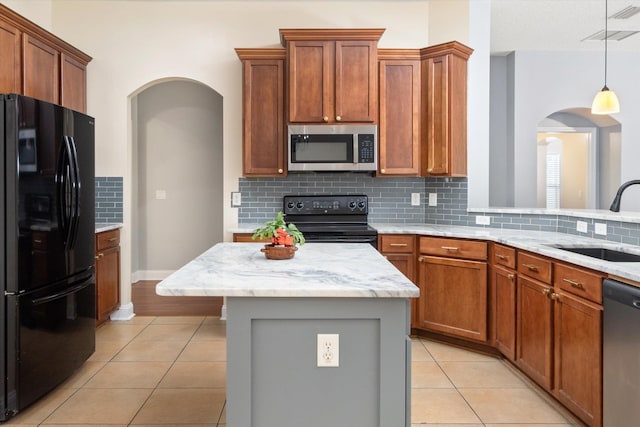 kitchen with sink, decorative light fixtures, a center island, light tile patterned floors, and black appliances