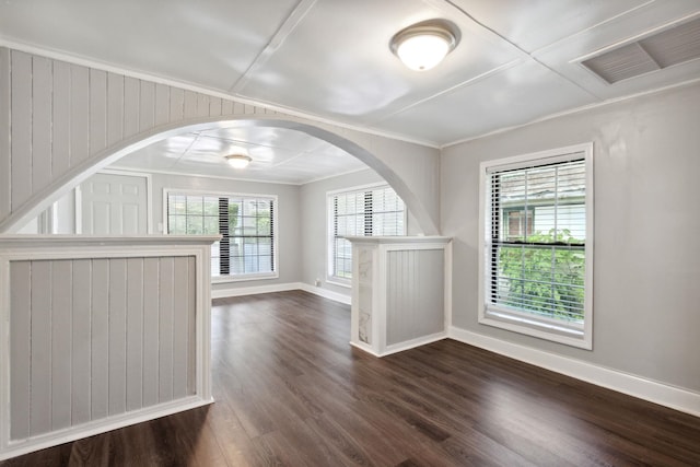 unfurnished living room with dark hardwood / wood-style floors, crown molding, and wooden walls