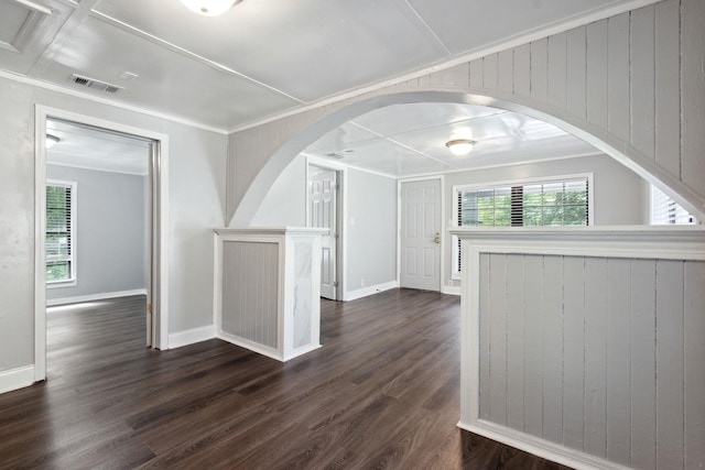 empty room with ornamental molding, dark hardwood / wood-style floors, and wooden walls