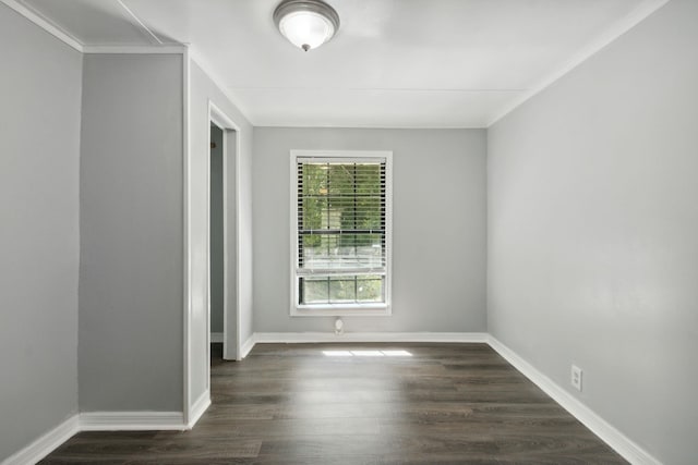 spare room with dark hardwood / wood-style floors and crown molding