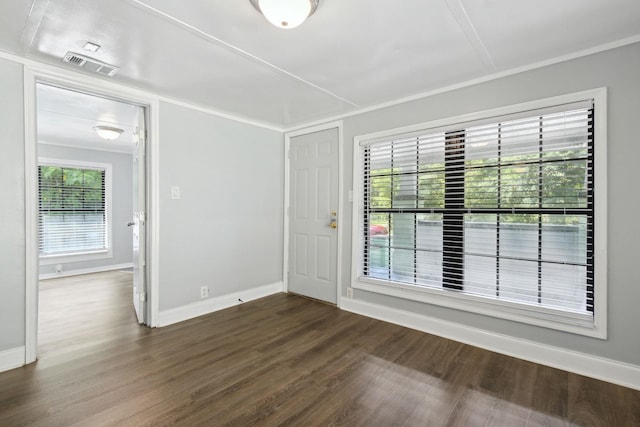 spare room featuring dark hardwood / wood-style flooring, plenty of natural light, and crown molding