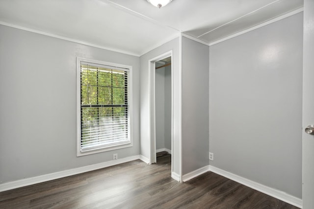 unfurnished bedroom with ornamental molding, a closet, and dark wood-type flooring