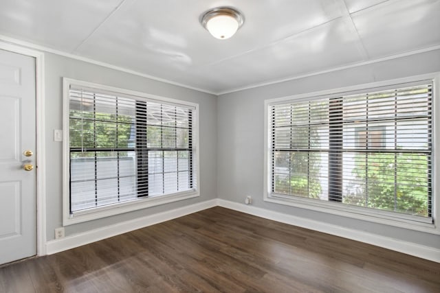 spare room featuring dark hardwood / wood-style floors and ornamental molding