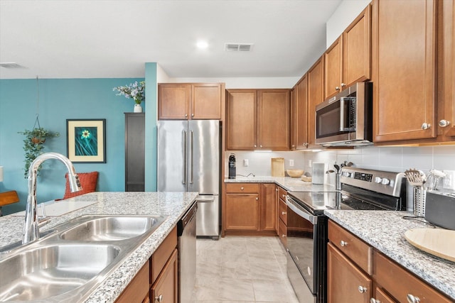 kitchen with appliances with stainless steel finishes, sink, decorative backsplash, and light tile patterned floors