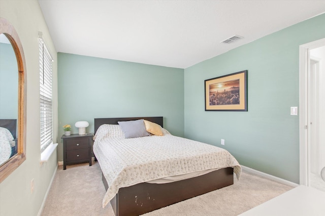 bedroom with light colored carpet and multiple windows