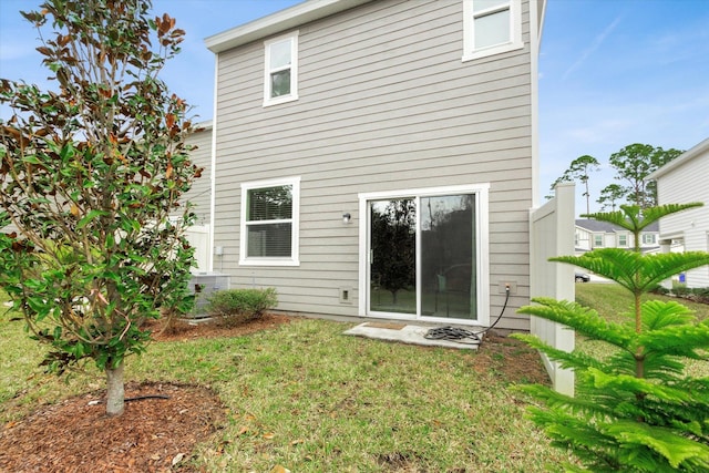 back of house featuring a lawn